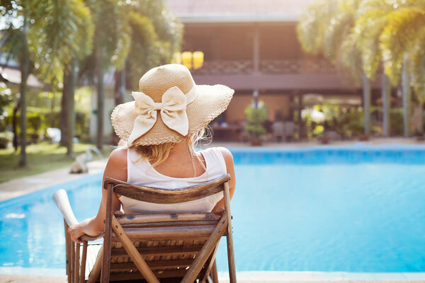 summer holidays in luxury hotel, woman relaxing near beautiful swimming pool