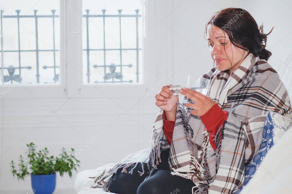 flu and fever, sick cold woman at home taking medicine pills