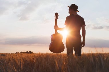 gitar günbatımı Field'da müzisyenle silüeti