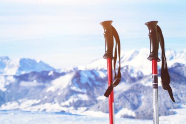 skiing in Alps, close up of two ski poles on mountains background clipart