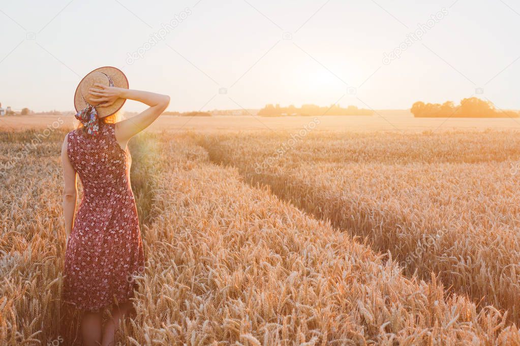 summer happy young woman in wheat field by sunset, daydream, beautiful background with place for text