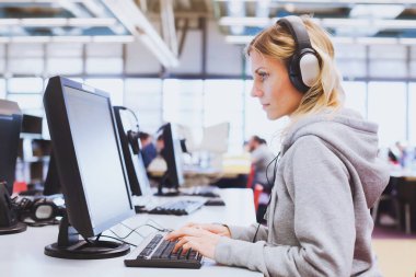 Yetişkin eğitimi, öğrenci kitaplığı veya sınıf Üniversitesi bilgisayarda çalışma kulaklık
