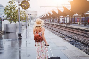 Tren ile kadın Tren İstasyonu platformunda bekleyen Bagaj ile seyahat