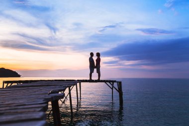 güzel romantik aşk arka plan, günbatımı Plajı'nda iskelede sevgi çift silüeti