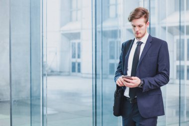 Ofis Binası yakınındaki Smartphone kullanarak iş adamı