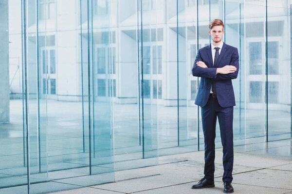 businessman standing on abstract business background, full body portrait