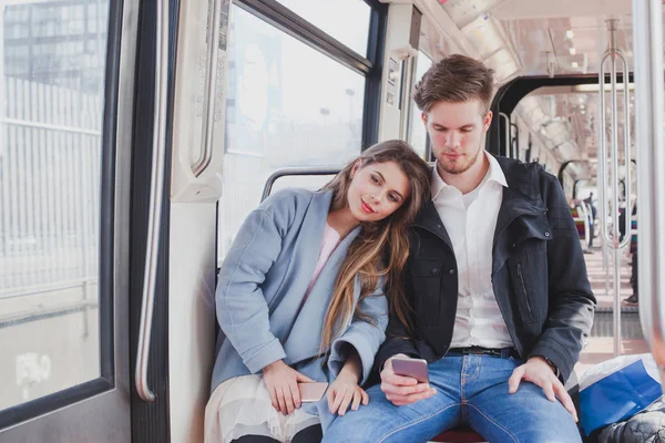 一緒に座って通勤者が地下鉄 若いカップル — ストック写真