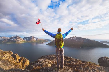 Norveç, dağın ayakta ve Norveç bayrağı tutarak sırt çantası ile mutlu turizm uzun yürüyüşe çıkan kimse seyahat