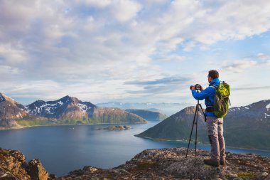 manzara fotoğrafçı ile sırt çantası dağın tepesinde duran güzel vahşi doğada tripod ve dslr fotoğraf makinesi ile çalışma