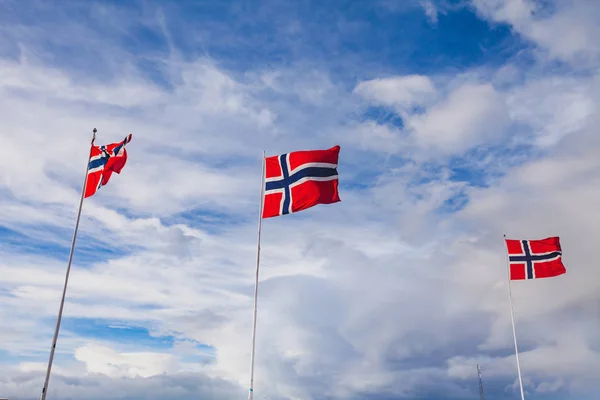 Norway, norwegian flags waving on blue sky background