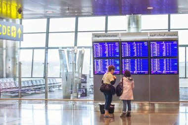 Doha, Katar - 25 Nisan 2017: takvim ekran Doha Uluslararası Havaalanı bakarak yolcu