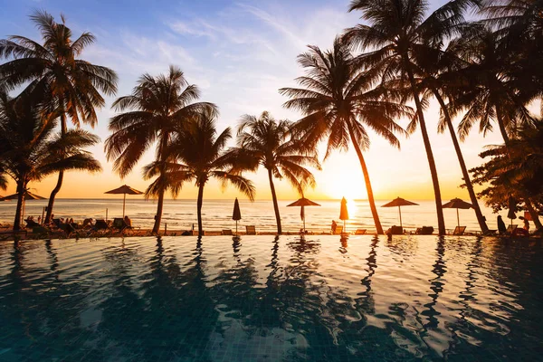 ビーチ 休日背景 ホテルのプールでヤシの木のシルエットの反射に沈む夕日 — ストック写真