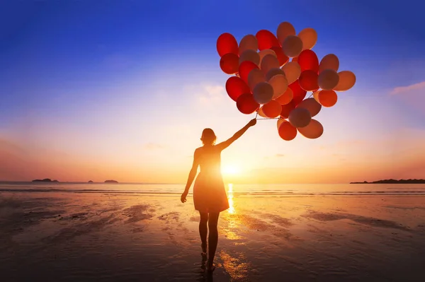 喜悦和幸福的概念 妇女的轮廓与许多飞行气球在海滩上 — 图库照片