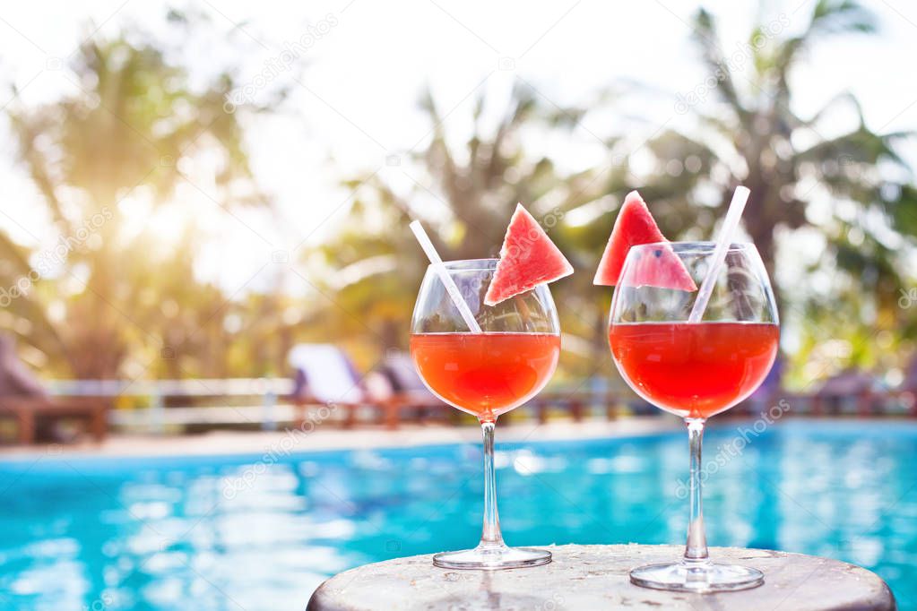 beach holidays background with two cocktails near swimming pool in luxurious hotel, tourism