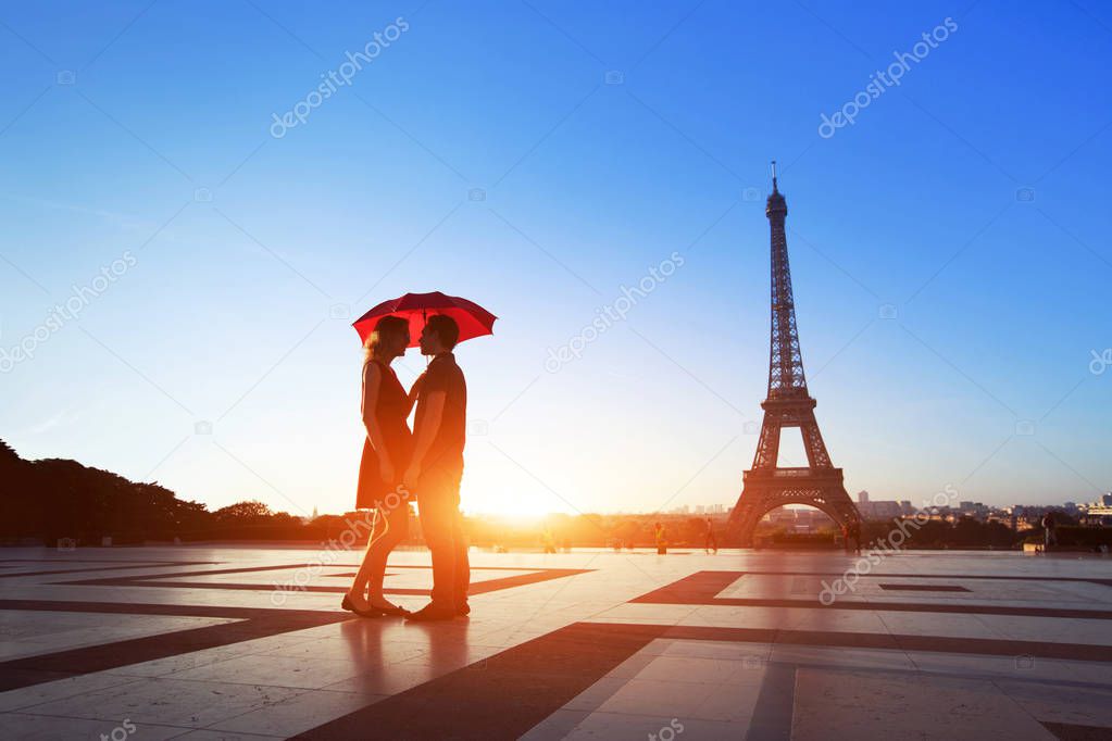 romantic couple in Paris, man and woman under umbrella near Eiffel Tower, honeymoon