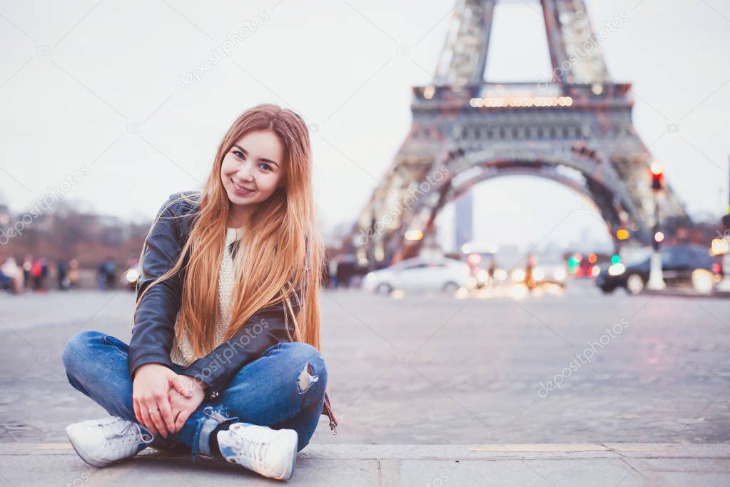 smiling happy beautiful woman tourist in Paris looking at camera, portrait of caucasian girl near Eiffel Tower