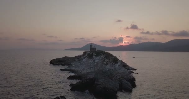 Vue aérienne à l'aube d'un phare au sommet d'un îlot rocheux sans végétation en face de Portoferraio, île d'Elbe (Italie) )