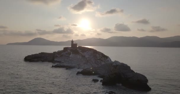 Vue aérienne à l'aube d'un phare au sommet d'un îlot rocheux sans végétation en face de Portoferraio, île d'Elbe (Italie) )