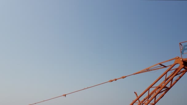 Оранжева журавля відокремлює блакитне небо — стокове відео