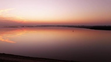 beautiful sunset over the lake with bird flying by 