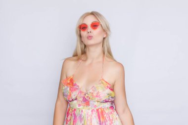 çiçekli pembe elbise ve parlak pembe güneş gözlüğü uzun saçlı Genç sarışın bir kadın portresi