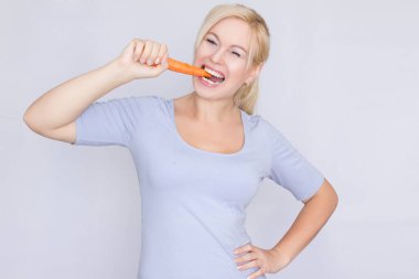 Genç Sarışın kadın genç büyük havuç dişleriyle ısırma