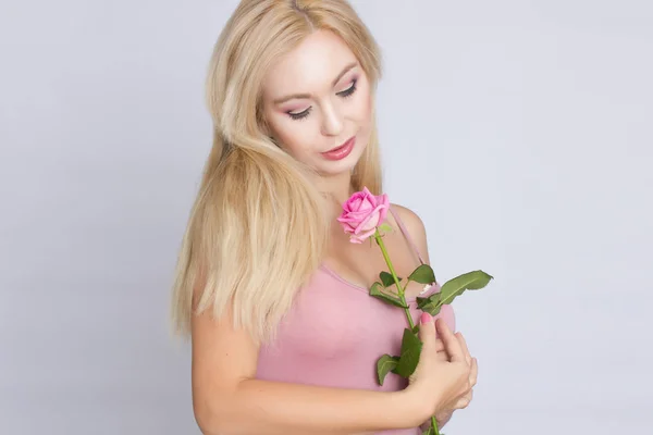 Uma Jovem Mulher Loira Bonito Segurando Uma Rosa Rosa — Fotografia de Stock