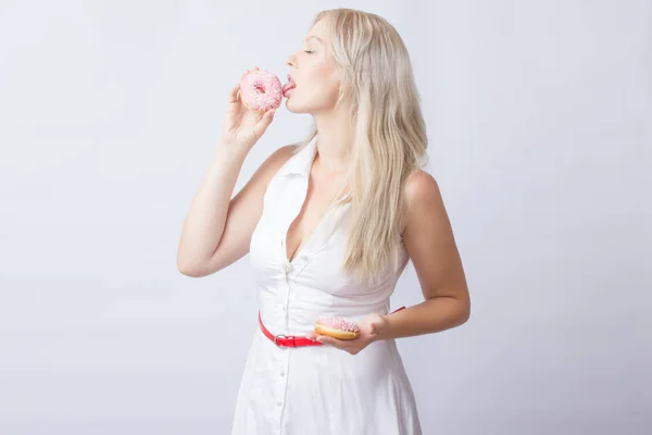 Młoda Blond Kobieta Białej Sukni Trzyma Ręce Różowy Pączek Lukier — Zdjęcie stockowe