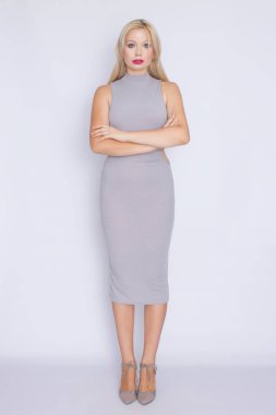 Stüdyo portre gri iş MIDI-elbiseli Genç bir sarışın kadının tam büyüme.