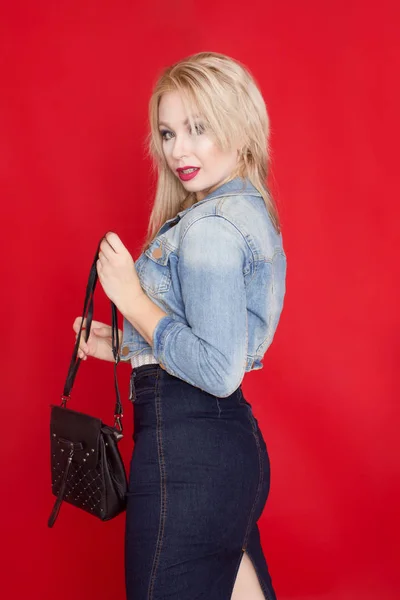 Сексуальна Блондинка Джинсовій Спідниці Піджак Позує Червоному Тлі Чорною Сумкою — стокове фото