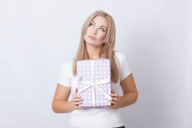 Hediye ile mutlu sevimli sarışın kadın kutu onun elinde gri arka plan üzerinde