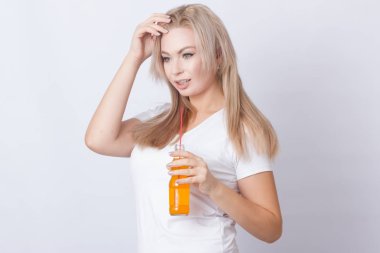 Stüdyo fotoğraf portre sevimli sarışın kadının ellerini soda şişesi ile. Gri arka plan üzerinde