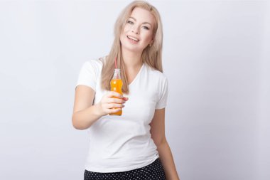 Stüdyo fotoğraf portre sevimli sarışın kadının ellerini soda şişesi ile. Gri arka plan üzerinde