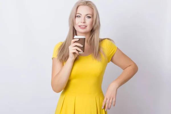 Schattige Blonde Vrouw Gele Jurk Koffiekopje Haar Handen Houden Grijs — Stockfoto