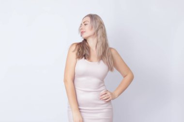 Stüdyo portre sarışın kadının bej beyaz arka plan üzerinde elbise. Kameraya bakarak ve duygular gösterilen