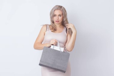 Closup stüdyo beyaz arka plan üzerinde şık sarışın kadın portresi. Kavram: alışveriş. Borth elinde çanta olan kadın