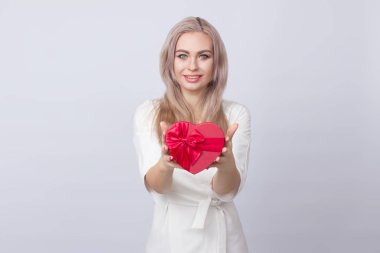 Sevgililer günü. Beyaz elbiseli sevimli sevimli sarışın kadın. Güzel kadın, kırmızı hediye kutusu kalp