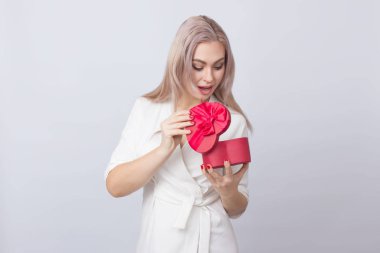 Sevgililer günü. Beyaz elbiseli sevimli sevimli sarışın kadın. Güzel kadın, kırmızı hediye kutusu kalp