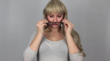 Gözleri gri arka plan üzerinde çekici sarışın kadın wearring gözlük