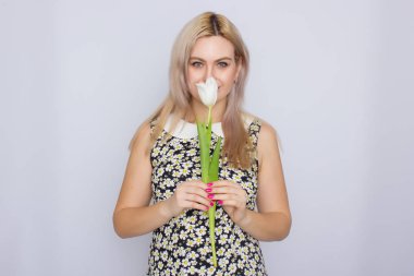 Bir Beyaz Lale tutan sarışın kadın