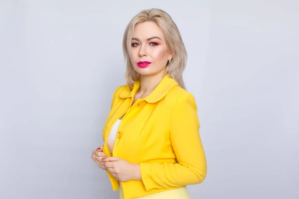Блондинка в жёлтом костюме — стоковое фото