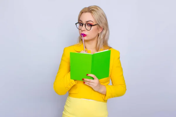 Портрет блондинки с книгами и ручкой — стоковое фото