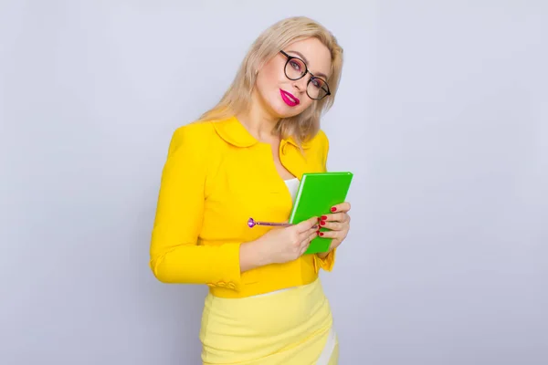 Porträtt av blond kvinna med böcker och penna — Stockfoto