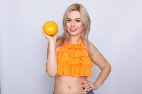 Blonde Frau mit orangefarbenen Zitrusfrüchten — Stockfoto