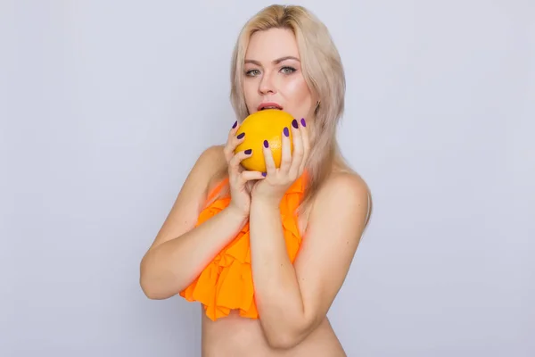 Blonde Frau mit orangefarbenen Zitrusfrüchten — Stockfoto