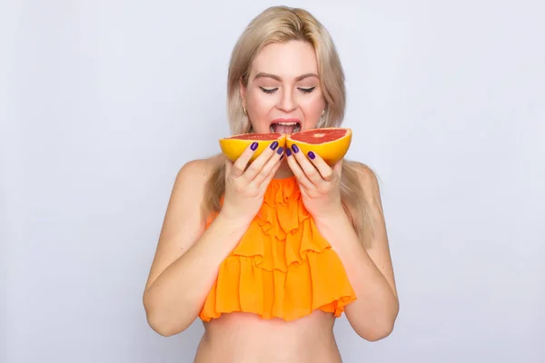 Blonde Frau mit Grapefruitscheiben — Stockfoto