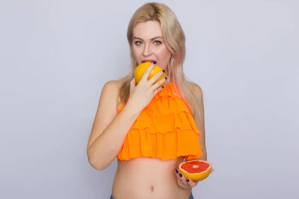 Blonde vrouw met grapefruit segmenten — Stockfoto