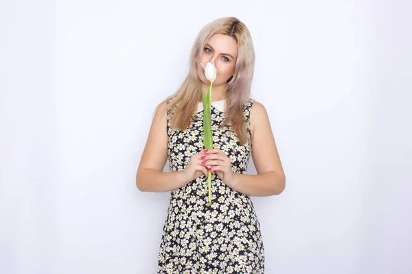 Blonde Frau hält eine weiße Tulpe in der Hand — Stockfoto
