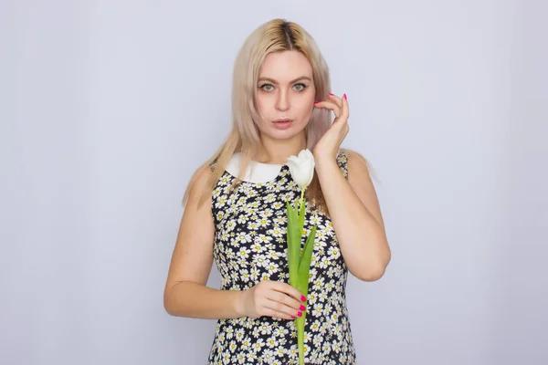 Blonde vrouw met een witte tulp — Stockfoto