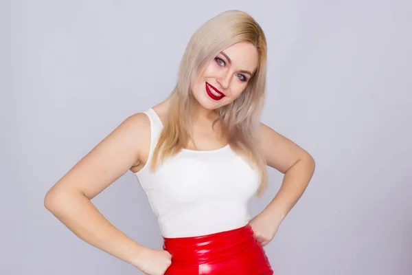 Блондинка в красной кожаной юбке и белой рубашке — стоковое фото